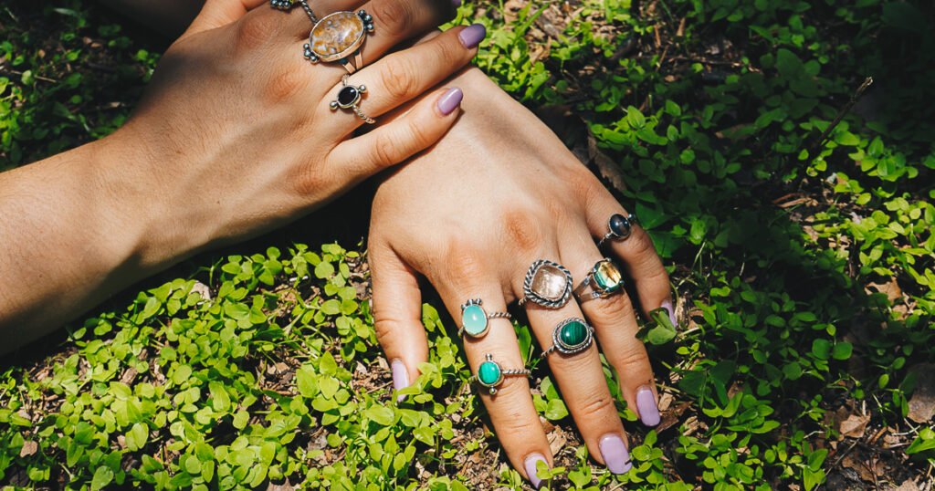 manos con anillos en plata sobre plantas verdes en bosque de la ciudad de mexico